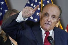 Rudy Giuliani gestures at a news conference.