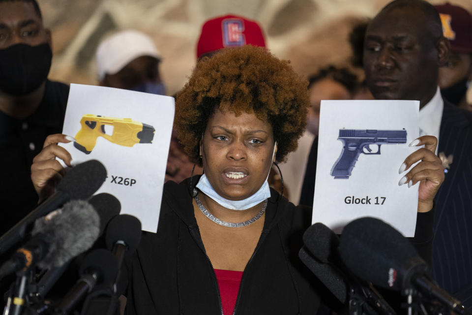 Naisha Wright, aunt of the deceased Daunte Wright, holds up images depicting X26P Taser and a Glock 17 handgun during a news conference at New Salem Missionary Baptist Church, Thursday, April 15, 2021, in Minneapolis. (AP Photo/John Minchillo)