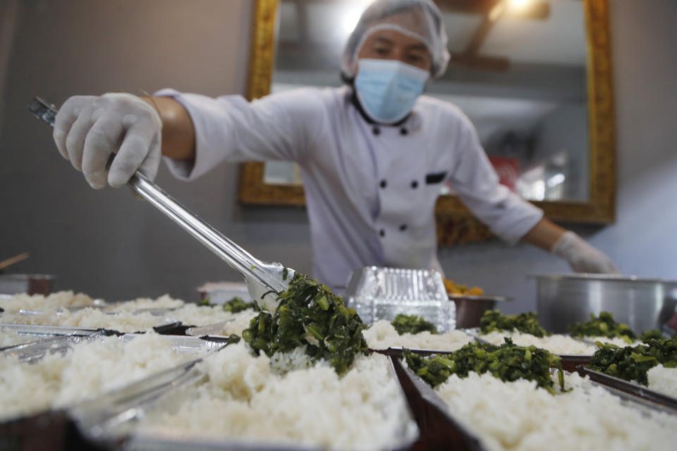 A Volunteer packs food to deliver to Teaching Hospital in Kathmandu, Nepal, Friday, Aug. 28, 2020. At one of the largest hospitals in Nepal, a pharmacist and taxi driver have teamed up to feed COVID-19 patients, doctors, nurses and health workers. Due to lockdowns, the cafeteria and nearby cafes have closed, leaving more than 200 staffers, patients and their families without food. The two friends have taken their own money and donations and put it to use buying groceries, renting a kitchen and paying helpers to provide the meals. (AP Photo/Niranjan Shrestha)