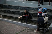 A man waits to have his clothes washed by the Ithaca mobile laundry service for the homeless in central Athens, Greece, February 12, 2017. REUTERS/Alkis Konstantinidis