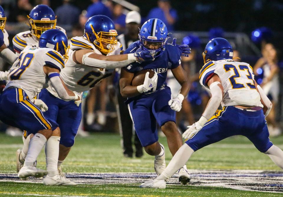 Sussex Central's Victor Perez (60) and Sam Pucci (23) try to corral move in on Middletown's Makai Walker in the first half of the Cavaliers' 41-7 win at Cavaliers Stadium, Friday, Sept. 8, 2023.