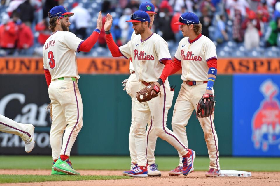 Philadelphia Phillies first base Bryce Harper (3), shortstop Trea Turner (7), and second base Bryson Stott (5) celebrate a win against the Chicago White Sox on Sunday, April 21, 2024, at Citizens Bank Park in Philadelphia. It's the Phillies sixth straight victory.
