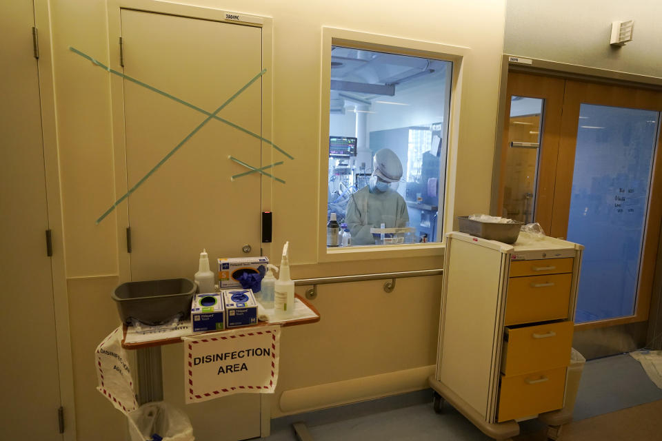 A healthcare worker tends to a COVID-19 patient in the intensive care unit at Santa Clara Valley Medical Center during the coronavirus pandemic in San Jose, Calif., Wednesday, Jan. 13, 2021. (AP Photo/Jeff Chiu)