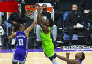 Minnesota Timberwolves forward Anthony Edwards (1) dunks as Sacramento Kings guard Tyrese Haliburton (0) defends during the first quarter of an NBA basketball game in Sacramento, Calif., Tuesday, April 20, 2021. (AP Photo/Randall Benton)