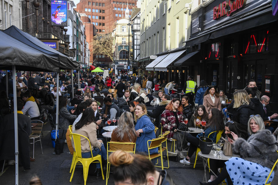 People sit, drinking and eating, outside cafes and pubs Soho, central London, on the day some of England's coronavirus lockdown restrictions were eased by the British government, Monday, April 12, 2021. People across England can get their hair cut, eat and drink outside at restaurants and browse for clothes, books and other "non-essential" items as shops and gyms reopened Monday after months of lockdown. (AP Photo/Alberto Pezzali)