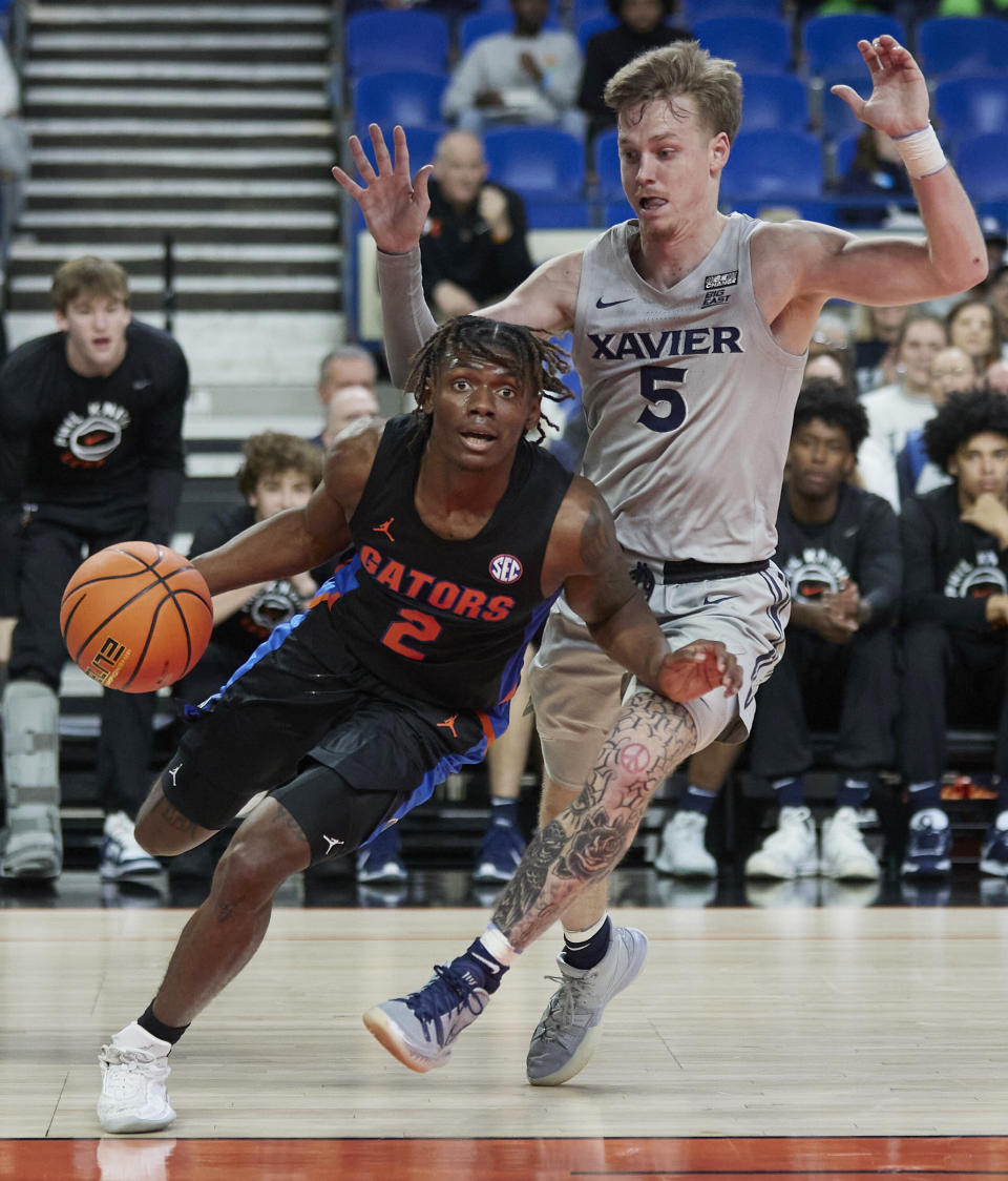 Florida guard Trey Bonham, left, drives around Xavier guard Adam Kunkel during the first half of an NCAA college basketball game in the Phil Knight Legacy tournament in Portland, Ore., Thursday, Nov. 24, 2022. (AP Photo/Craig Mitchelldyer)