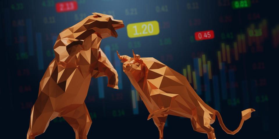 Animated bear and bull faces each other in front of stock charts