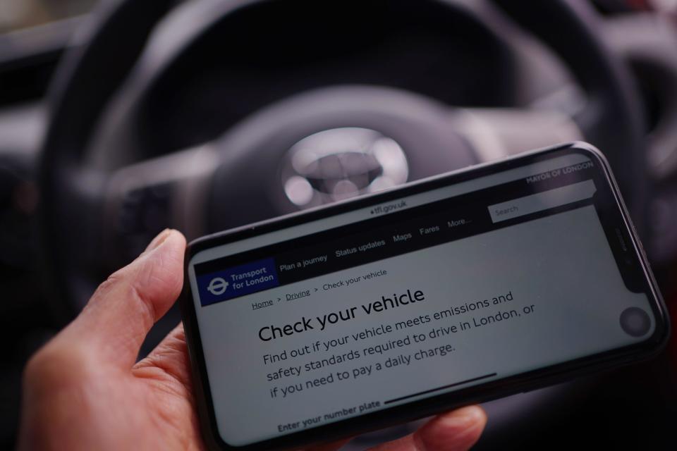 A person checks their vehicle on the Transport for London (TfL) webiste on a mobile phone, on the first day of the expansion of the ultra-low emission zone (Ulez) to include the whole of London. The capital has become the world's largest pollution charging area with a £12.50 daily fee for the most polluting vehicles. Picture date: Tuesday August 29, 2023.