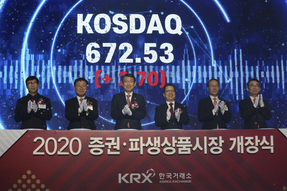 Jung Ji-won, third from right, chief executive of the Korea Exchange, and Financial Services Commission Chairman Eun Sung-soo, third from left, applaud with other participants during the opening of this year's trading in Seoul, South Korea, Thursday, Jan. 2, 2020. The sign read: "Opening ceremony of 2020 trading." (AP Photo/Ahn Young-joon)