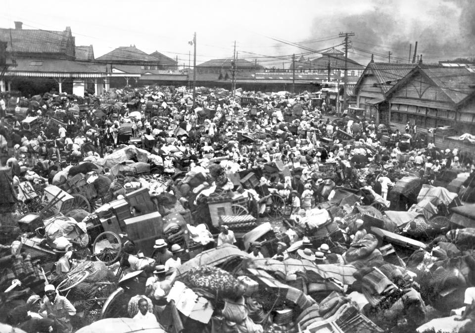 People displaced after an earthquake carry their belongings as they crowd at a square in front of Ueno station in Tokyo on Sept. 1, 1923. On Friday, Sept. 1, 2023, Japan marked the centennial of the 1923 Great Kanto Quake that killed more than 100,000. (Kyodo News via AP)