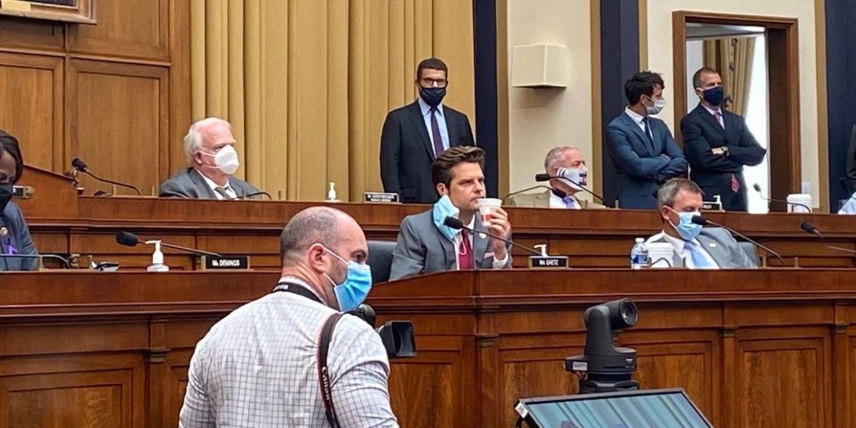 Rep. Matt Gaetz takes his mask off to sip a beverage in the hearing room.