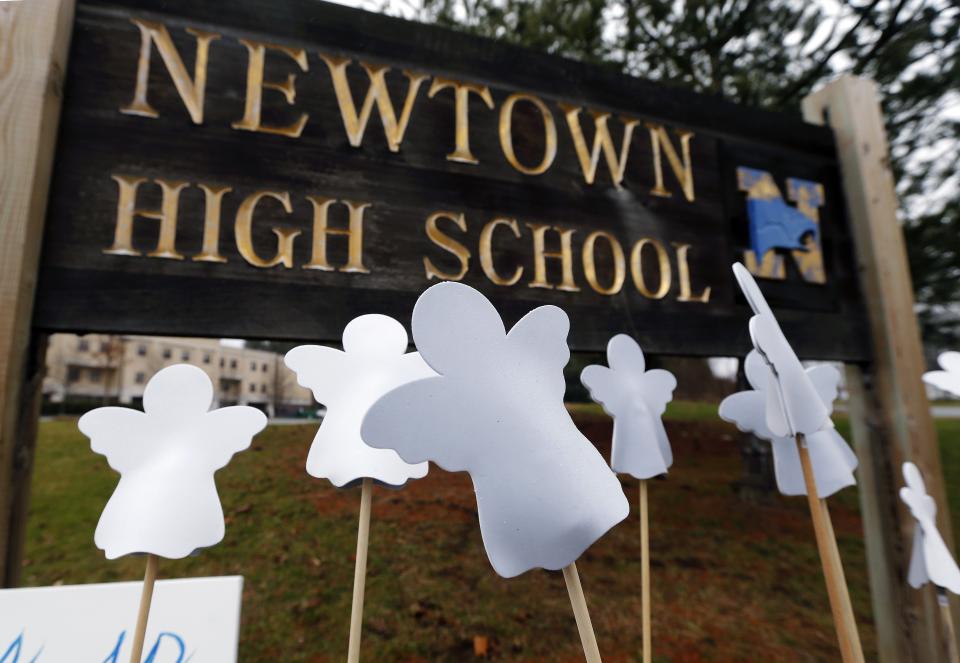 Angel cut-outs are displayed outside Newtown High School in Newtown, Conn., Sunday, Dec. 16, 2012. A gunman opened fire at Sandy Hook Elementary School in the town, killing 26 people, including 20 children before killing himself on Friday. (AP Photo/Charles Krupa)