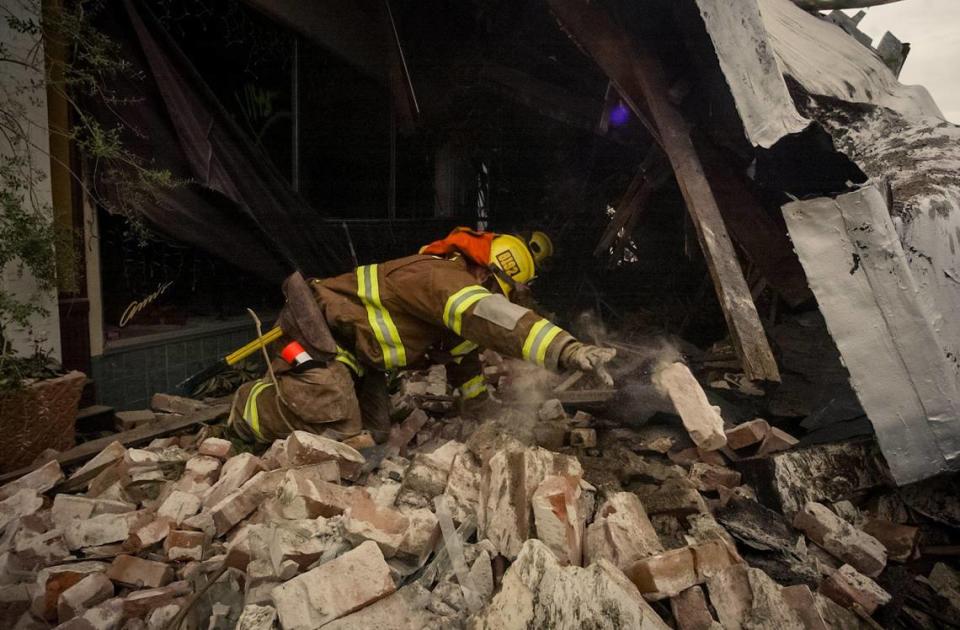 Firefighter searches the rubble on Pine Street in Paso Robles after an unreinforced masonry building collapsed during the San Simeon Earthquake, Dec. 22, 2003.