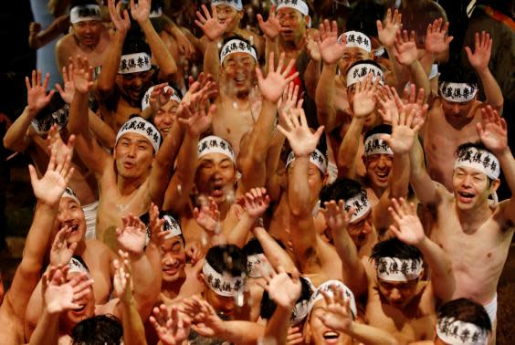 Men dressed in loincloths react as a priest splashes water on them before they prepare to snatch a wooden stick called ‘shingi‘ (REUTERS)