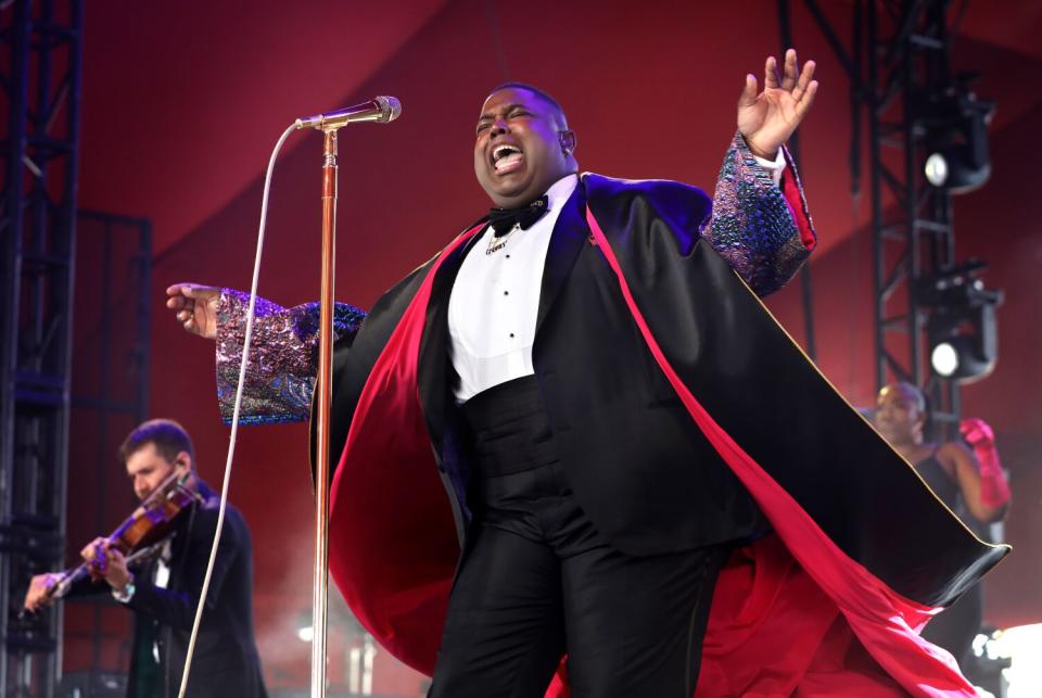 A singer in a tuxedo performs onstage