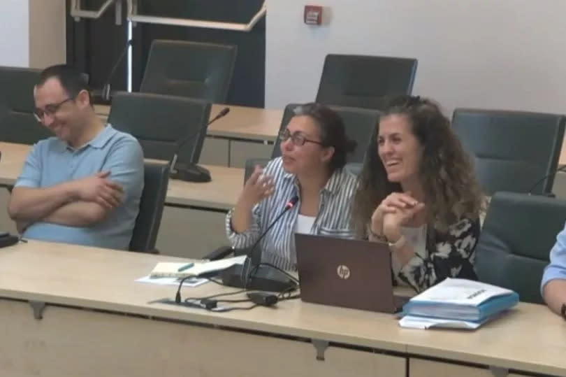 Two women sat at table at council meeting