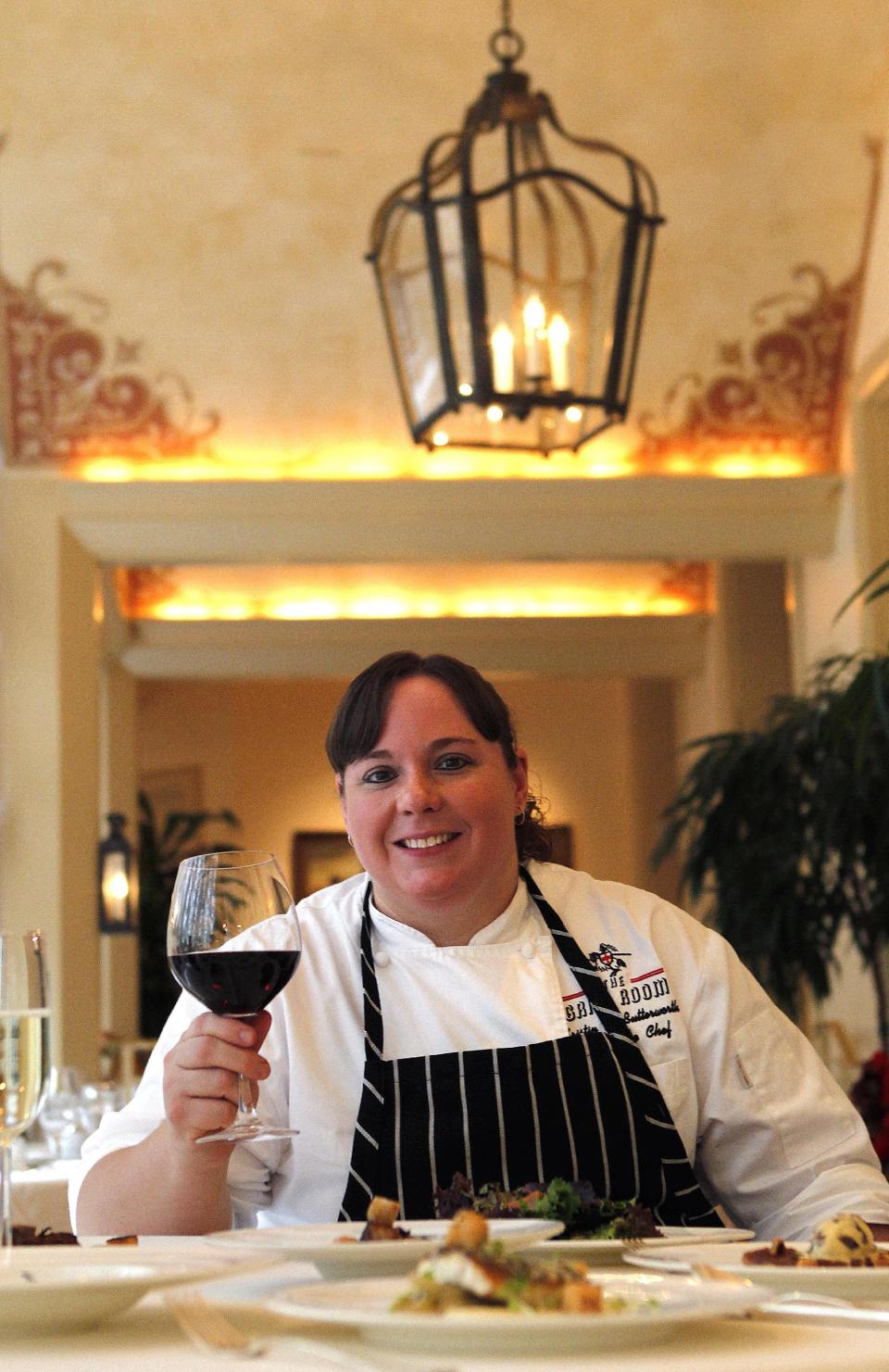 In this Dec. 7, 2012 photo, executive chef Kristin Butterworth poses for a photograph with her reveillon menu at the Grill Room of the Windsor Court Hotel in New Orleans. Roughly 50 restaurants in New Orleans are reviving an old Creole custom called reveillon, which stems from the old French tradition of eating a lavish meal after midnight Mass on Christmas Eve. (AP Photo/Gerald Herbert)