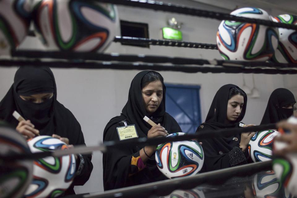 Employees conduct a final check on balls inside the soccer ball factory that produces official match balls for the 2014 World Cup in Brazil, in Sialkot, Punjab province