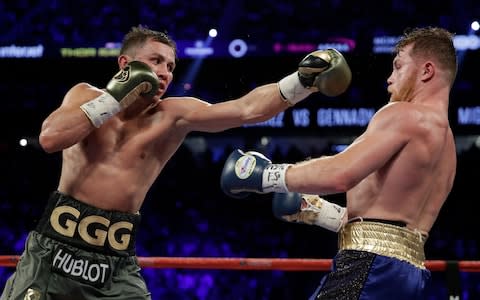 Gennady Golovkin, left, throws a left at Canelo Alvarez  - Credit: AP