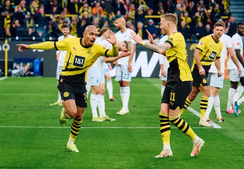 Dortmund's Donyell Malen (L) celebrates scoring his side's first goal with teammate Marco Reus during the German Bundesliga soccer match between Borussia Dortmund and TSG 1899 Hoffenheim at Signal Iduna Park. Bernd Thissen/dpa