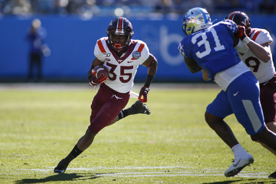 Virginia Tech running back Keshawn King, left, carries the ball as Kentucky linebacker Jamar Watson (31) pursues in the first half of the Belk Bowl NCAA college football game in Charlotte, N.C., Tuesday, Dec. 31, 2019. (AP Photo/Nell Redmond)