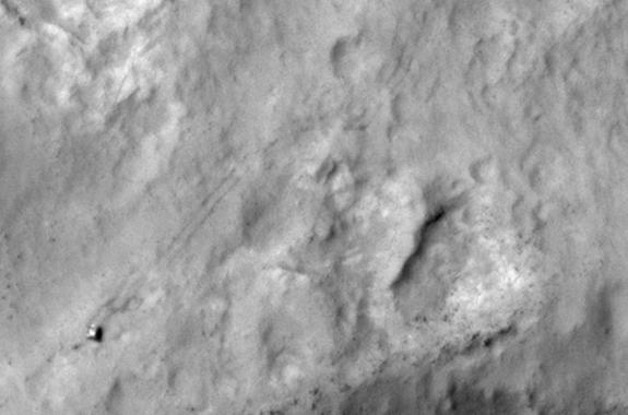 NASA's Curiosity Mars rover and tracks left by its driving appear in this portion of a Dec. 11, 2013, observation by the High Resolution Imaging Science Experiment (HiRISE) camera on NASA's Mars Reconnaissance Orbiter. The rover is near the low