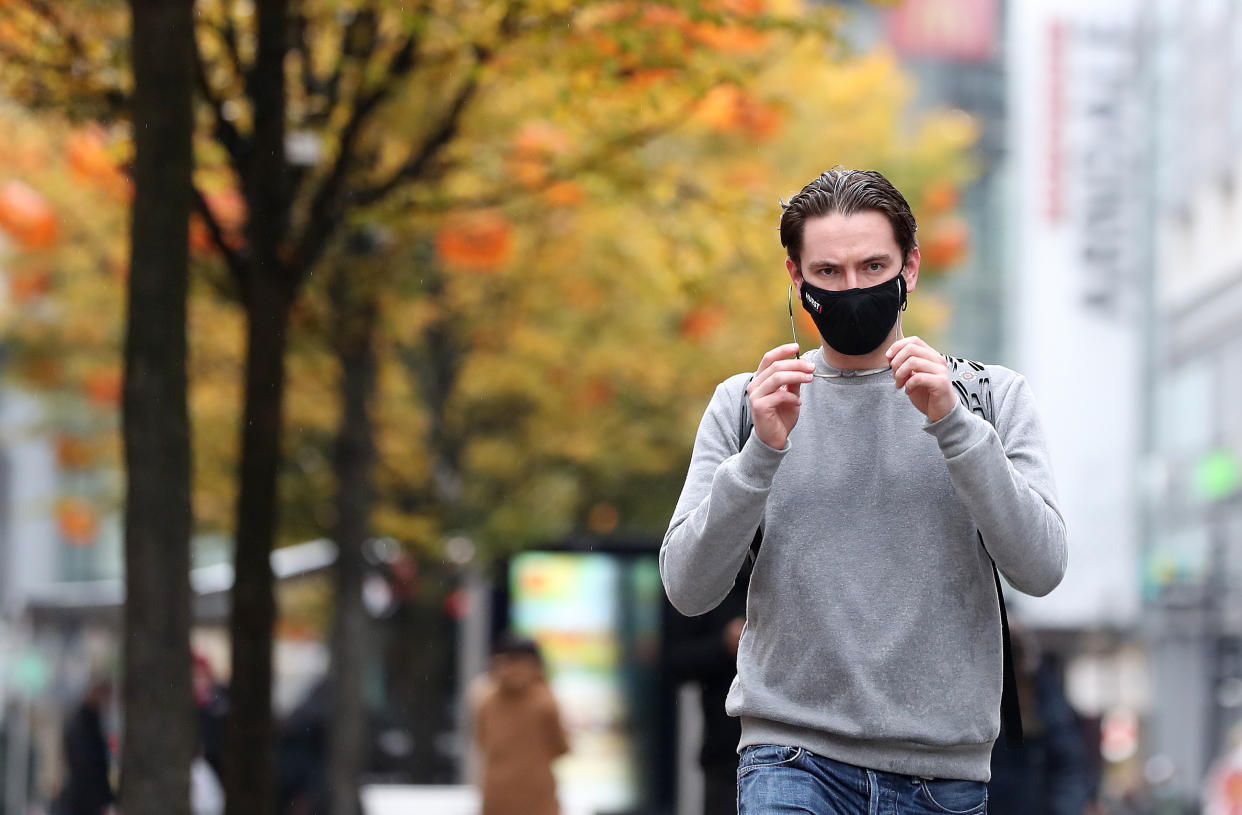 A person wearing a face mask walks down Market street in Manchester. Stringent Tier 3 coronavirus restrictions have been imposed on the Greater Manchester area after negotiations between ministers and local leaders broke down after more than a week. (Photo by Martin Rickett/PA Images via Getty Images)