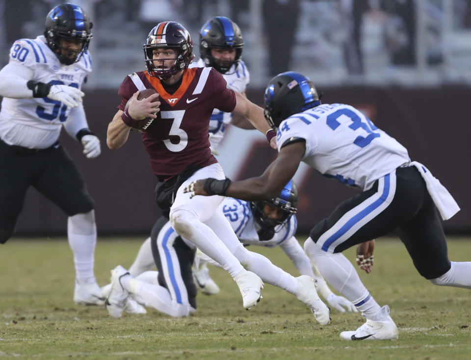 Virginia Tech quarterback Braxton Burmeister (3) runs the ball while defended by Duke's Jalen Alexander (32) and Sayyid Stevens (34) in the first half of an NCAA college football game in Blacksburg Va., Saturday, Nov. 13 2021. (Matt Gentry/The Roanoke Times via AP)