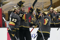 Vegas Golden Knights players celebrate after defenseman Alec Martinez (23) scored against the St. Louis Blues during the second period of an NHL hockey game Friday, May 7, 2021, in Las Vegas. (AP Photo/John Locher)