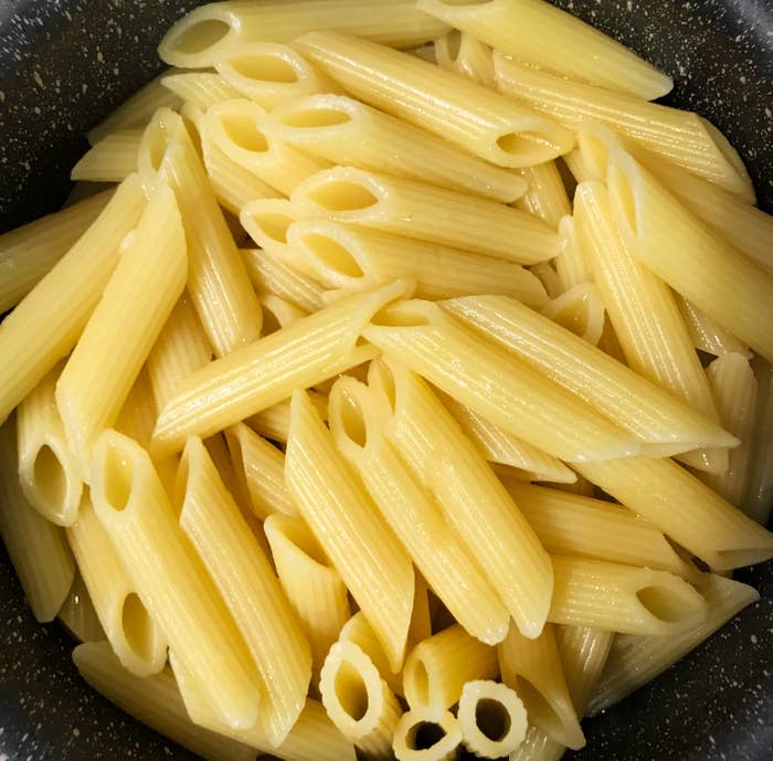 A close-up view of cooked penne pasta in a pot