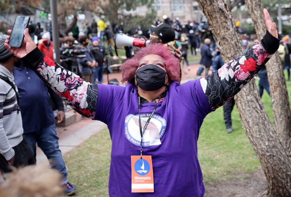 A woman raises her arms.