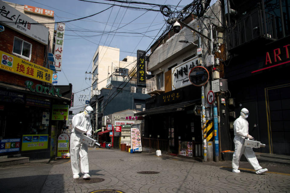 Photo shows workers in PPE spraying disinfectant in Seoul's Itaewon area to protect against the coronavirus.