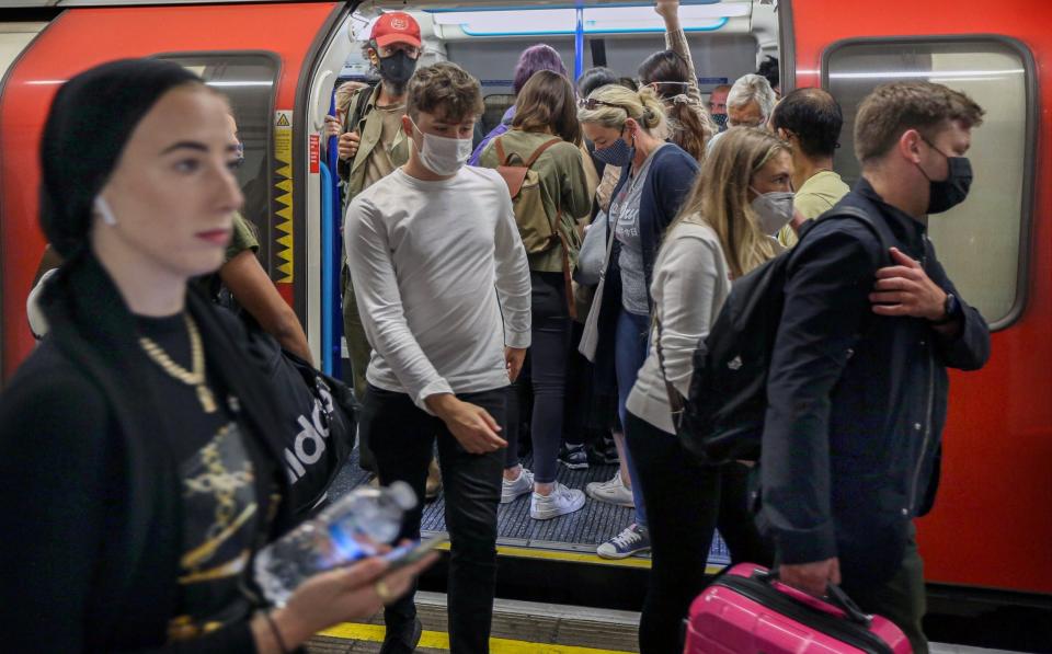 Passengers leave a busy underground train still wearing their facemasks in London - SOPA Images/LightRocket