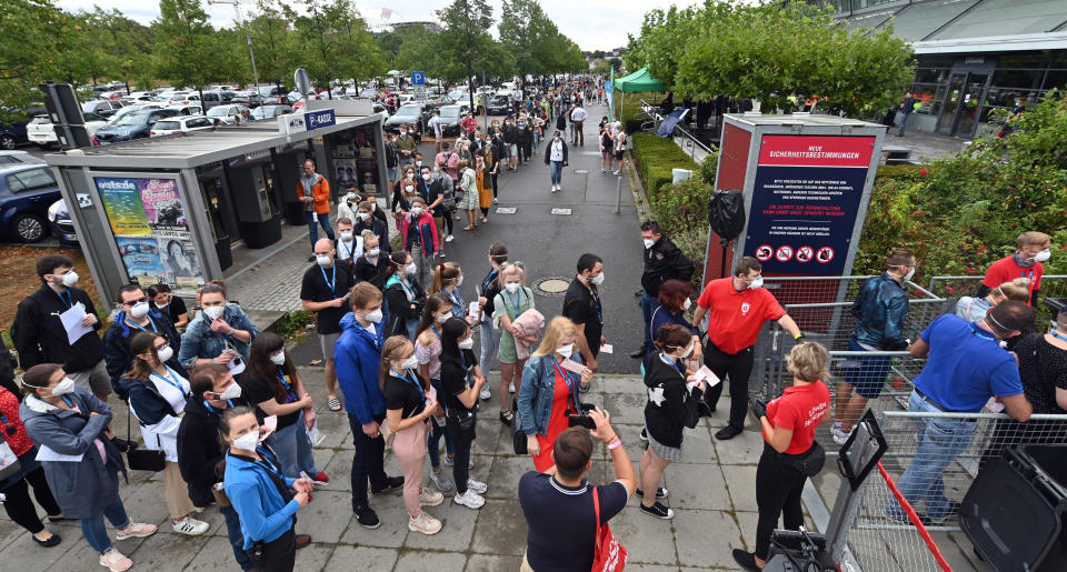 22 August 2020, Saxony, Leipzig: Test persons of a large-scale experiment of the University Medicine Halle/Saale are standing at the entrance in front of the Arena Leipzig. Around 2200 visitors take part in the experiment entitled "Restart-19", in which pop singer Tim Bendzko will perform. The scientists want to use sensors and other aids to monitor walking paths and fluorescent disinfectant is to make visible which surfaces are often touched. They also want to trace the flight of aerosols - the smallest mixtures of particles that could carry the virus. The aim is to develop a mathematical model with which the risk of a corona outbreak after a major event in a hall can be assessed. Photo: Hendrik Schmidt/dpa-Zentralbild/dpa (Photo by Hendrik Schmidt/picture alliance via Getty Images)