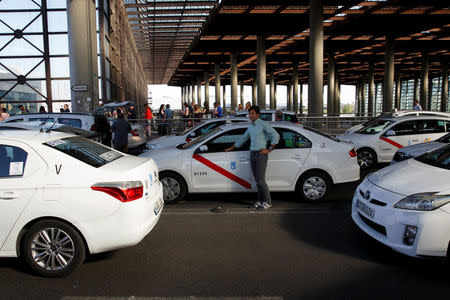 Alberto Lamelas stands beside his taxi as he waits in queue for costumers at Atocha rail station in Madrid, Spain, June 14, 2017. REUTERS/Sergio Perez