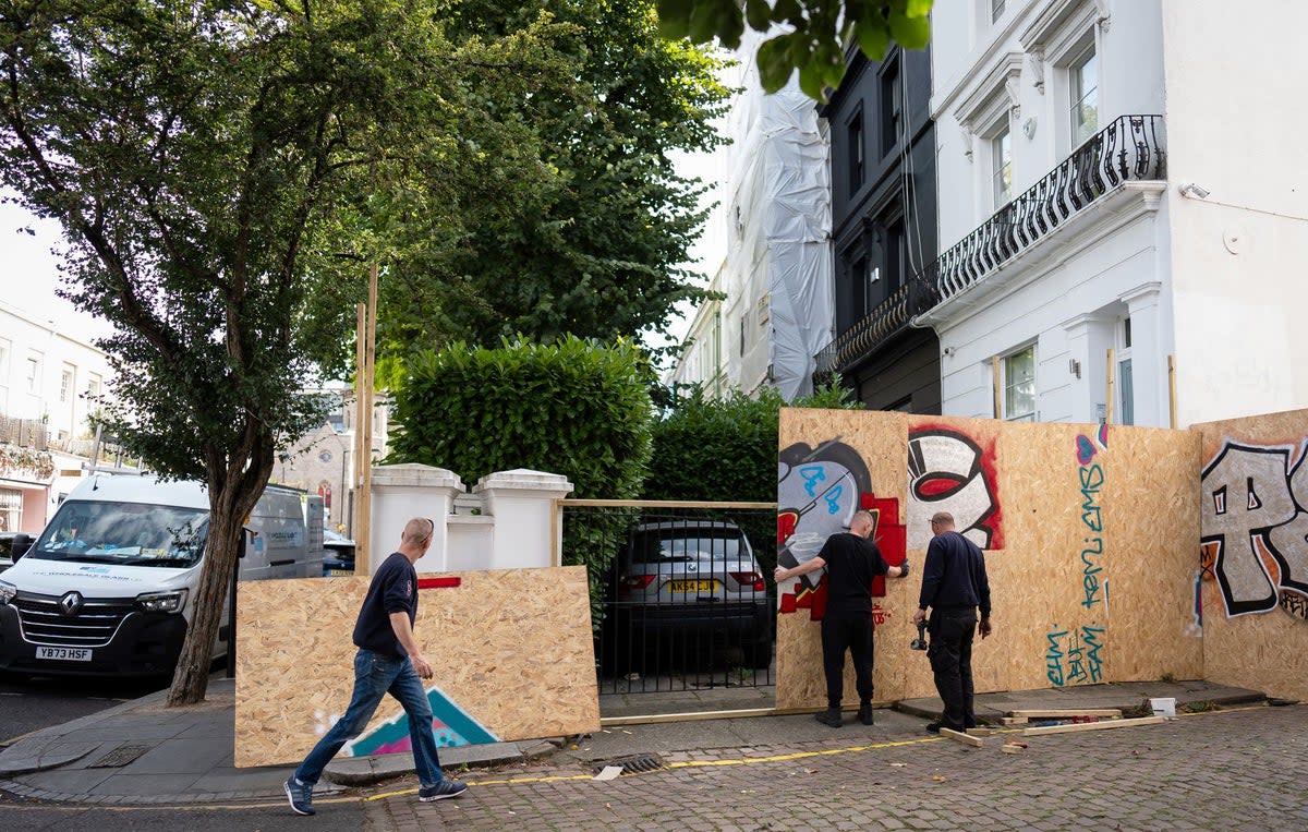 Workmen attach boards to a property as preparations continue ahead of this year's Notting Hill Carnival (Aaron Chown/PA Wire)