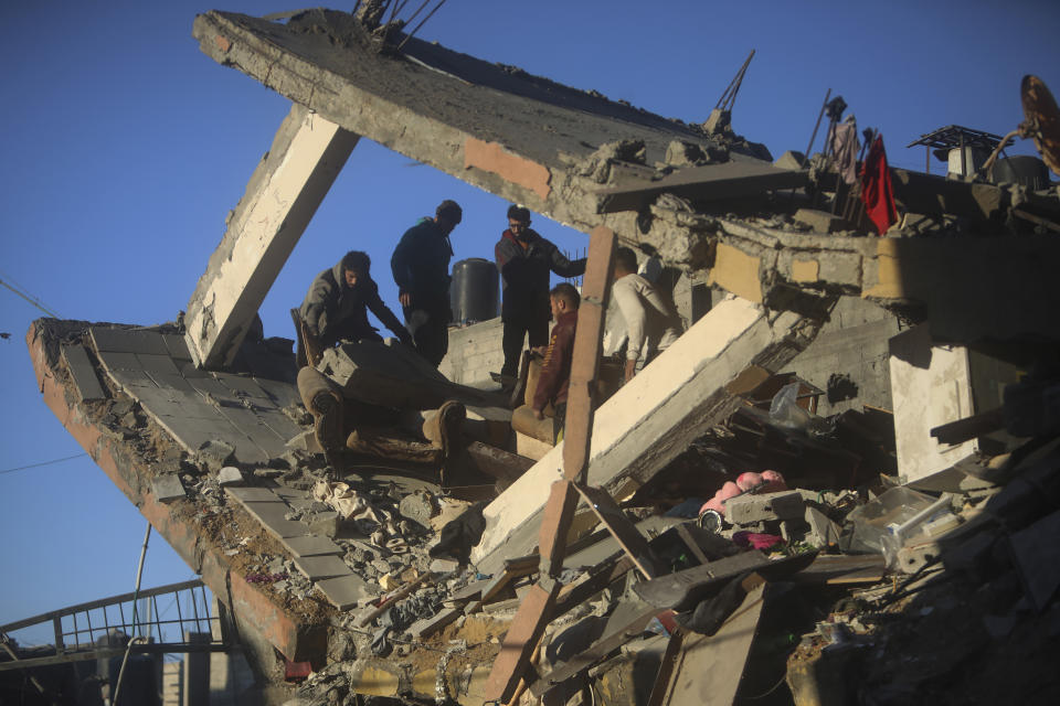 Palestinians inspect the damage of a destroyed house following Israeli airstrikes on Khan Younis, Southern Gaza Strip, Sunday, Jan. 7, 2024. (AP Photo/Mohammed Dahman)