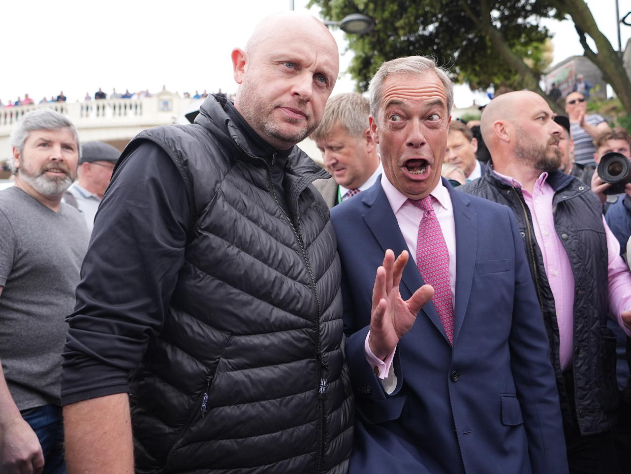 Leader of Reform UK Nigel Farage pulls a face while speaking to a supporter in Clacton, Essex (James Manning/PA)