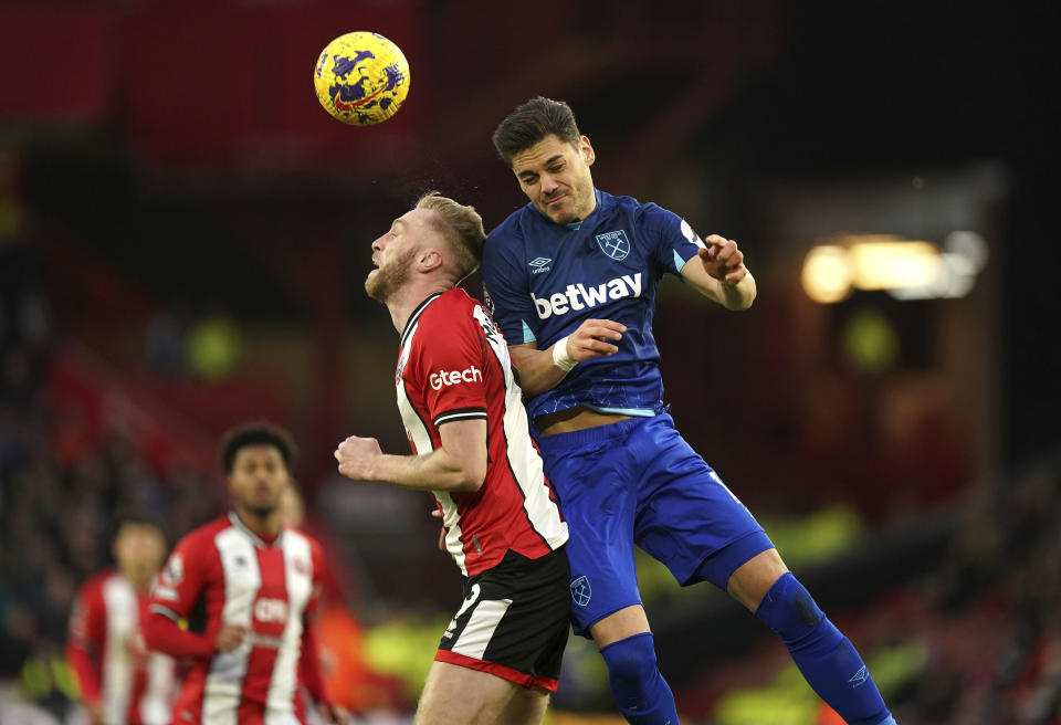 Sheffield United's Oli McBurnie , left and West Ham United's Konstantinos Mavropanos battle for the ball, during the English Premier League soccer match between Sheffield United and West Ham United at Bramall Lane, in Sheffield, England, Sunday, Jan. 21, 2024. (Mike Egerton/PA via AP)