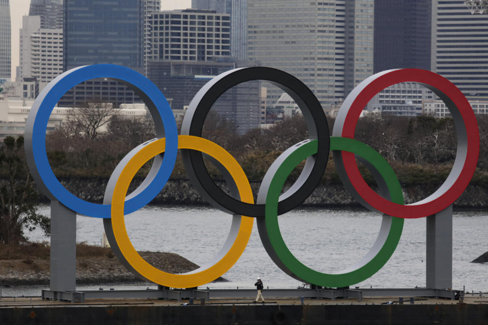 A worker is dwarfed by the Olympics Rings on a barge Friday, Jan. 17, 2020, in the Odaiba district of Tokyo. (AP Photo/Jae C. Hong)