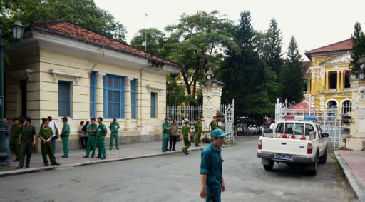 Policemen and security staff stand outside the main entrance gate of Ho Chi Minh City's People's Court. A court in southern Vietnam jailed three bloggers Monday for "anti-state propaganda" at a brief but dramatic hearing, prompting calls from the United States and EU for their immediate release