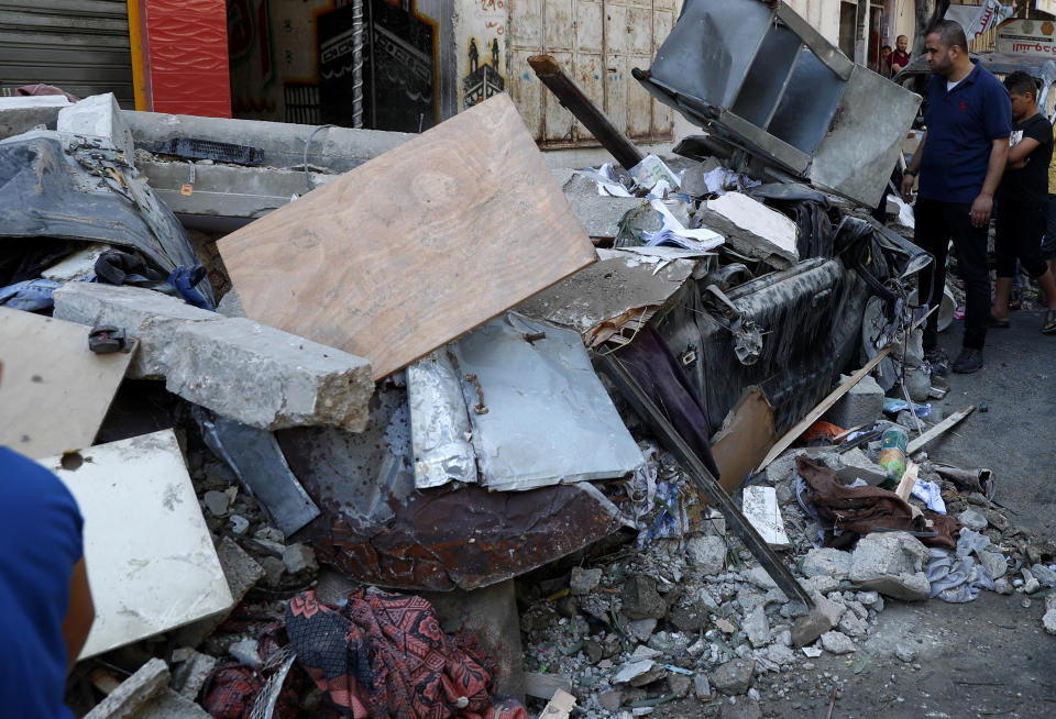 People inspect the rubble of the destroyed Abu Hussein building that was hit by an Israeli airstrike in the early morning in Gaza City, Wednesday, May 19, 2021. (AP Photo/Adel Hana)