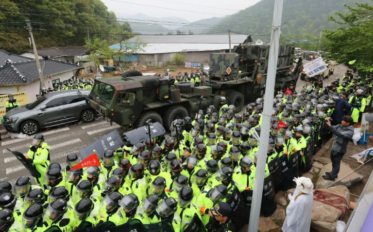 Protesters and police gather to watch as trailers carrying US THAAD missile defence equipment enter a deployment site in Seongju, South Korea