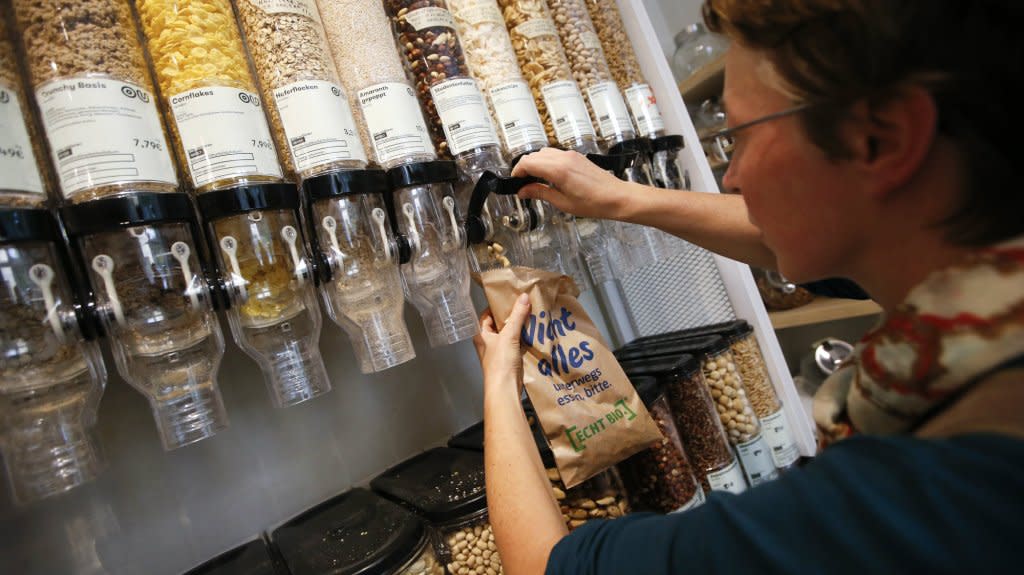A customer fills up a bag with nuts at a grocery store in Berlin.