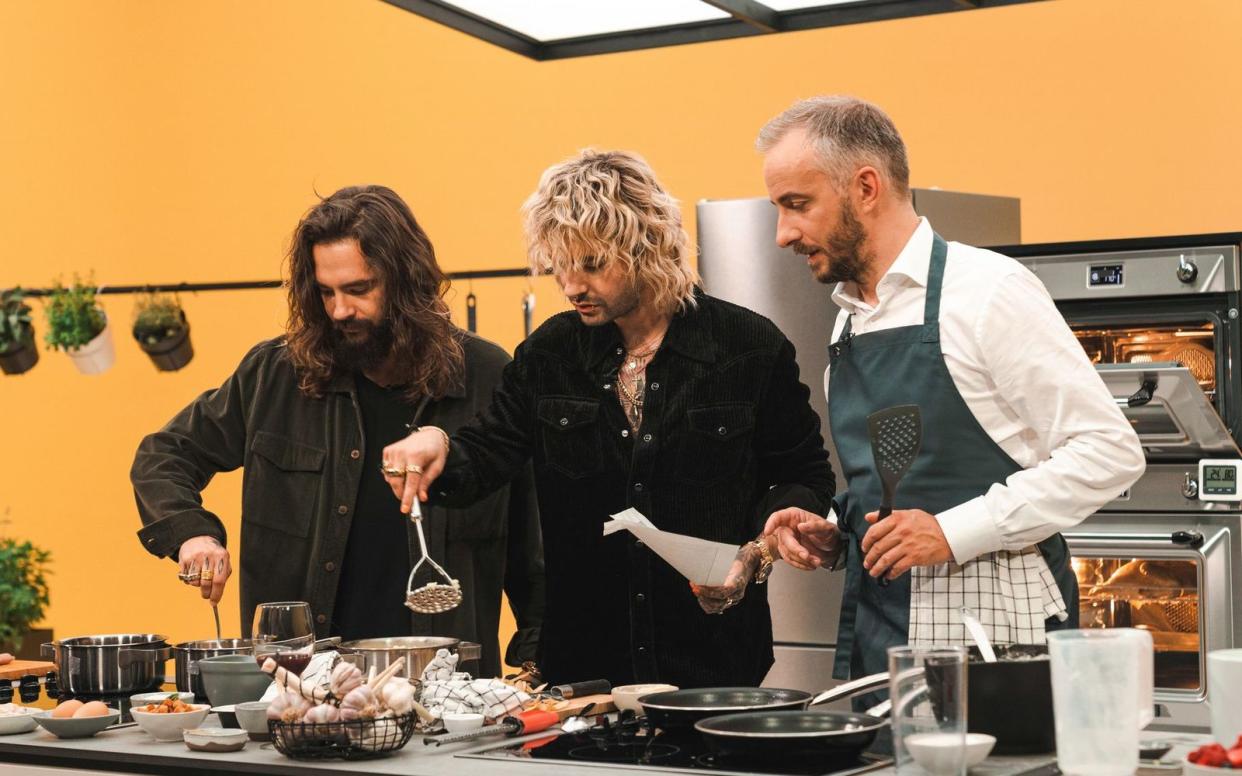 Gelingt der Kartoffelstampf? Bill (Mitte) und Tom Kaulitz geben sich Mühe bei Jan Böhermanns (rechts) "Böhmi brutzelt". (Bild: ZDF / Felix Hackland)