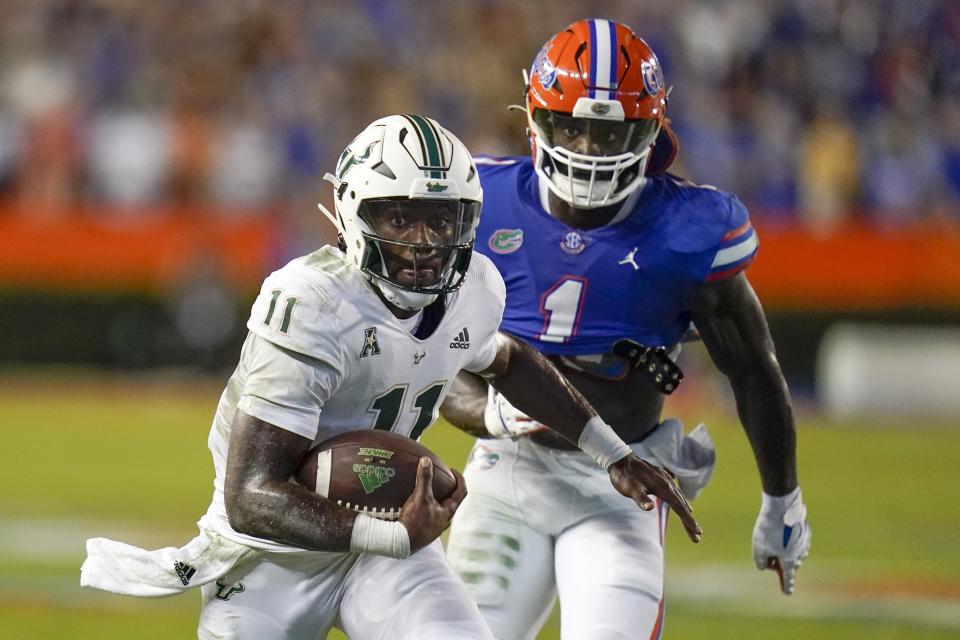 South Florida quarterback Gerry Bohanon (11) scrambles for yardages past Florida linebacker Brenton Cox Jr. (1) during the first half of an NCAA college football game, Saturday, Sept. 17, 2022, in Gainesville, Fla. (AP Photo/John Raoux)