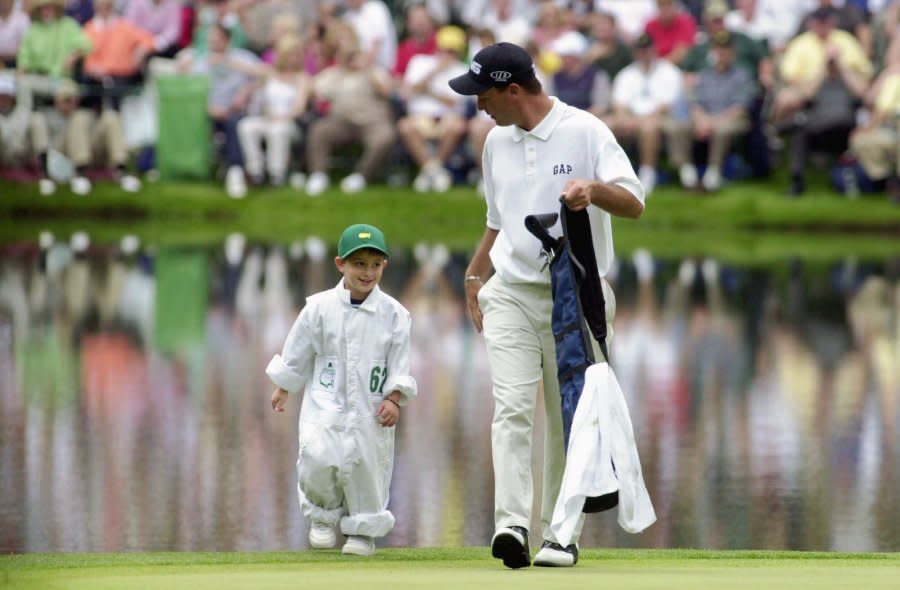 Chris DiMarco grabs his clubs from his son and caddie, Cristian Alexander DiMarco, 5, as they leave the 8th green during the Par 3 Contest at the Augusta National Golf Club in Augusta, Ga., Wednesday, April 4, 2001, as part of the Masters festivities. First round Masters play begins Thursday. (AP Photo/Amy Sancetta)