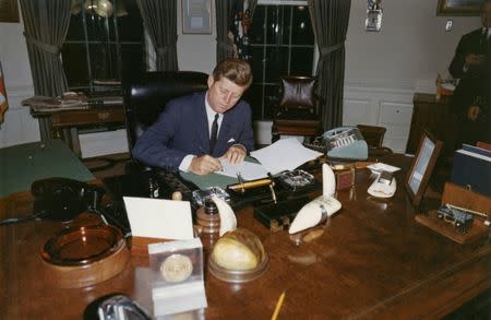 FILE PHOTO: U.S. President John F. Kennedy signs a proclamation for the interdiction of the delivery of offensive weapons to Cuba during the Cuban missile crisis, at the White House in Washington, DC October 23, 1962. Cecil Stoughton/The White House/John F. Kennedy Presidential Library/File Photo via REUTERS