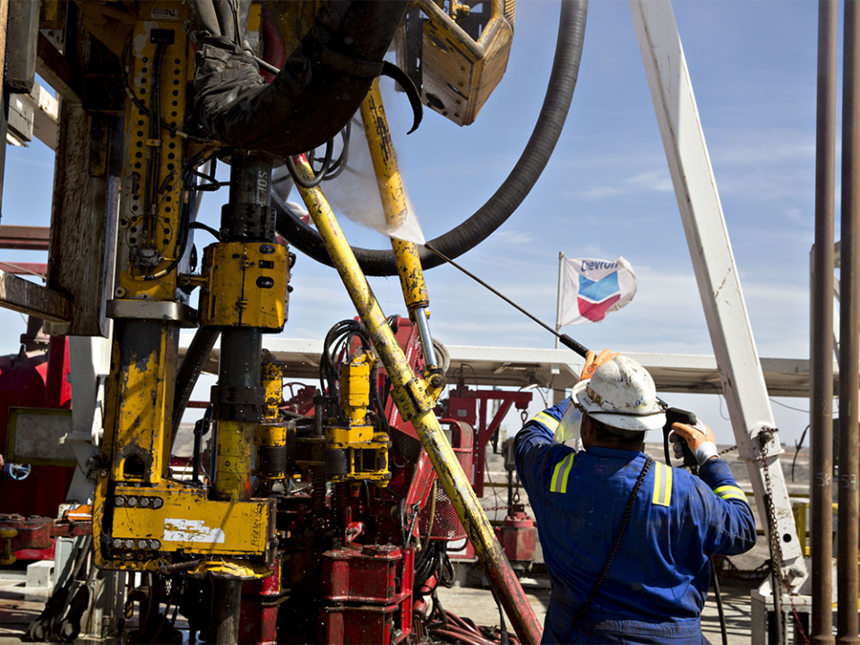  A roughneck cleans the floor of a rig drilling for Chevron Corp. in the Permian Basin near Midland, Tex.