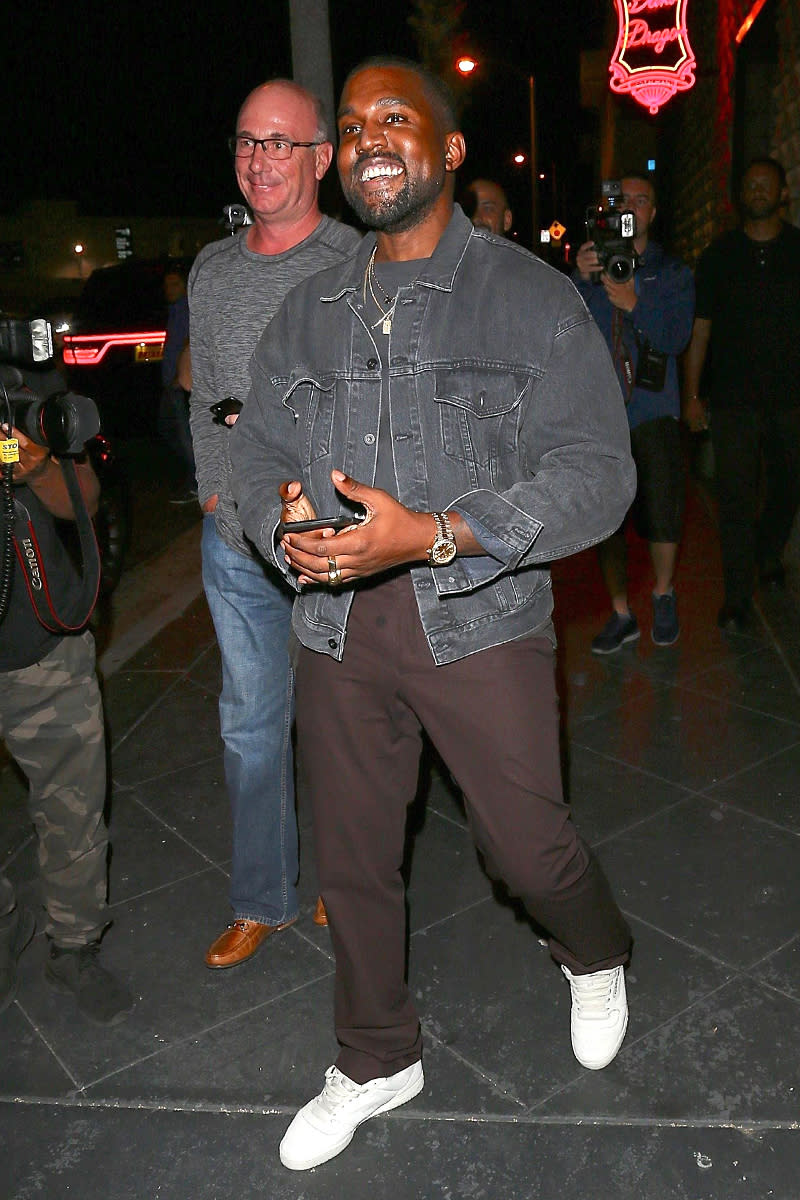 <p>West is often serious, but he flashed a smile at the paparazzi outside Khloé Kardashian’s <a rel="nofollow" href="https://www.yahoo.com/celebrity/khloe-kardashian-apos-boyfriend-tristan-093300586.html" data-ylk="slk:surprise birthday party;elm:context_link;itc:0;sec:content-canvas;outcm:mb_qualified_link;_E:mb_qualified_link;ct:story;" class="link  yahoo-link">surprise birthday party</a> Sunday in L.A. Hey, who wouldn’t be excited about gold-covered snacks! (Photo: BACKGRID) </p>